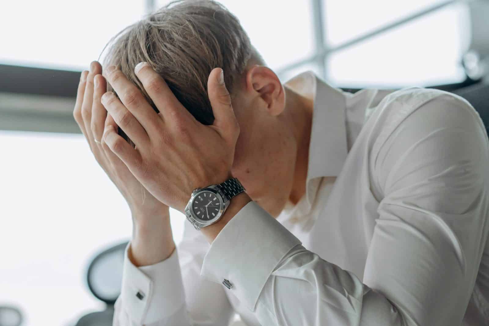 A business professional showing stress and fatigue with head in hands.